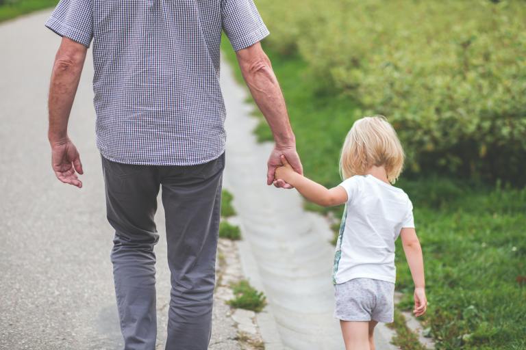 grandfather and granddaughter walking holding hands