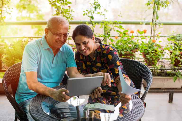 indian couple smiling looking at computer